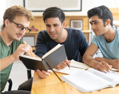 Bild zum Thema Lernoaching zeigt drei junge Studenten, die gemeinsam lernen